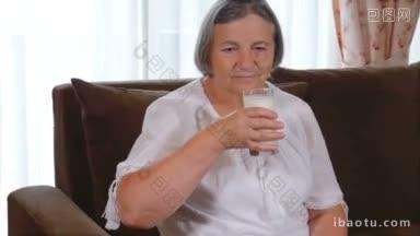 健康的老年女士喝着一杯新鲜的牛奶，<strong>带</strong>着欣赏和享受的微笑看着